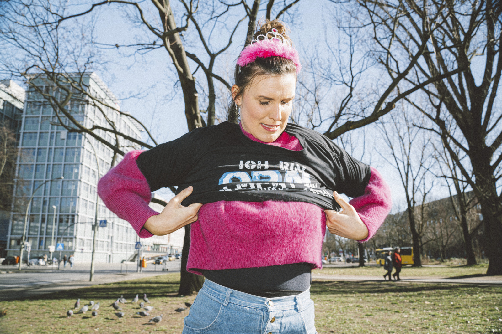 Eine Feministin zieht sich ein Motto-Shirt über den pinken Pulli