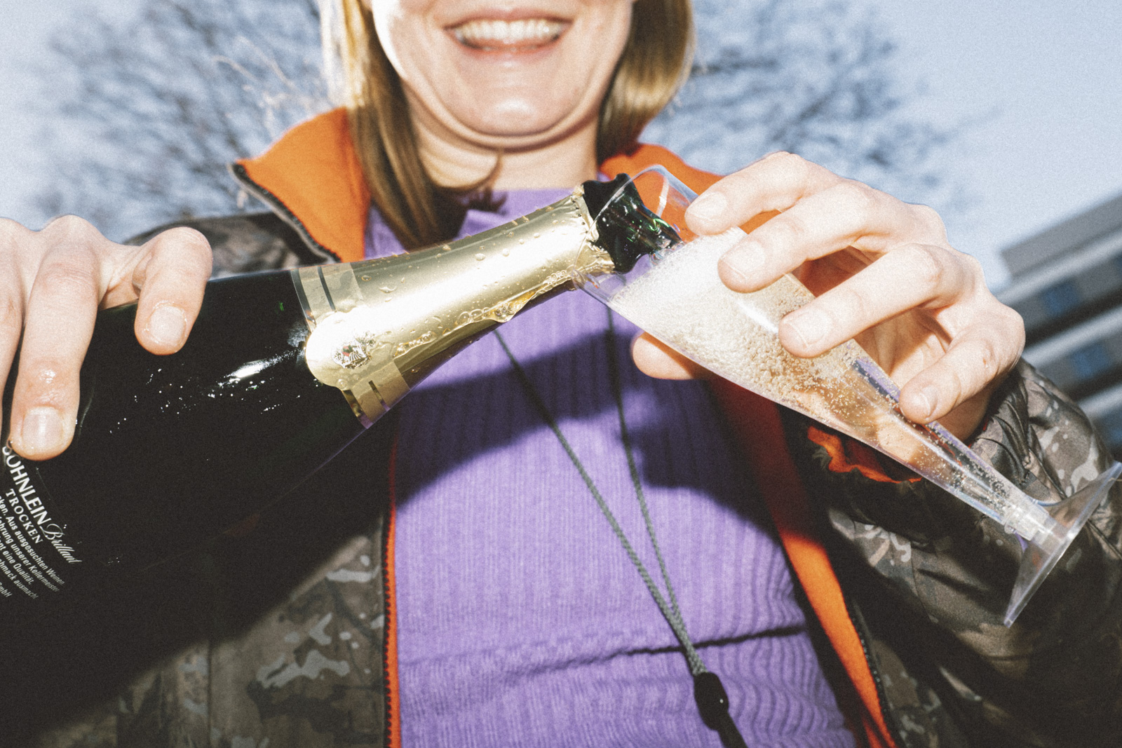 Johanna gießt Sekt in einen Plastikbecher