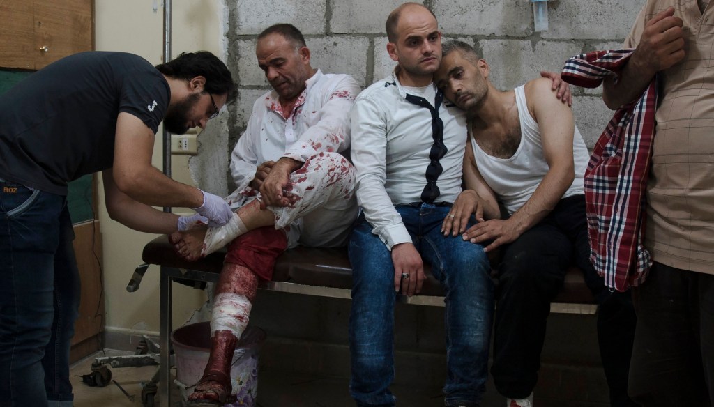 Syrian men wait to receive treatment at a make-shift hospital in the rebel-held Salihin neighbourhood of the northern city of Aleppo following a reported air strike on July 9, 2016.