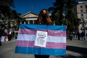 A protester showing a trans pride flag in front of the Congress of Deputies building in Madrid as a group start a hunger strike.