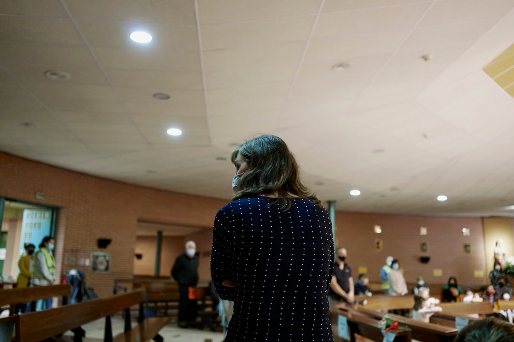 A stock image of a woman wearing a mask inside a church