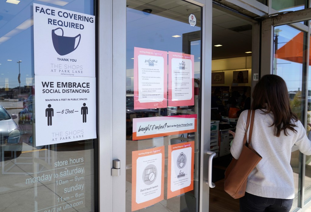 A customer enters a store with a face mask required sign displayed Tuesday, March 2, 2021, in Dallas. (AP Photo/LM Otero)