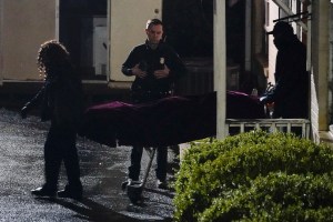 A police officer watches as a body is taken from the Gold Spa massage parlor after a shooting, late Tuesday, March 16, 2021, in Atlanta. (AP Photo/Brynn Anderson)