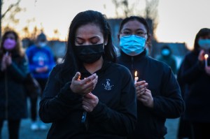 People hold candles while attending a vigil held for the victims of the shooting spree in Atlanta.