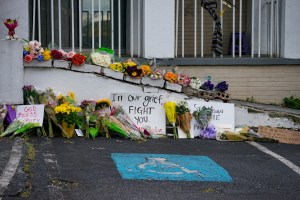 Flowers and signs adorn Gold Spa during a demonstration against violence against women and Asians following Tuesday night's shooting.