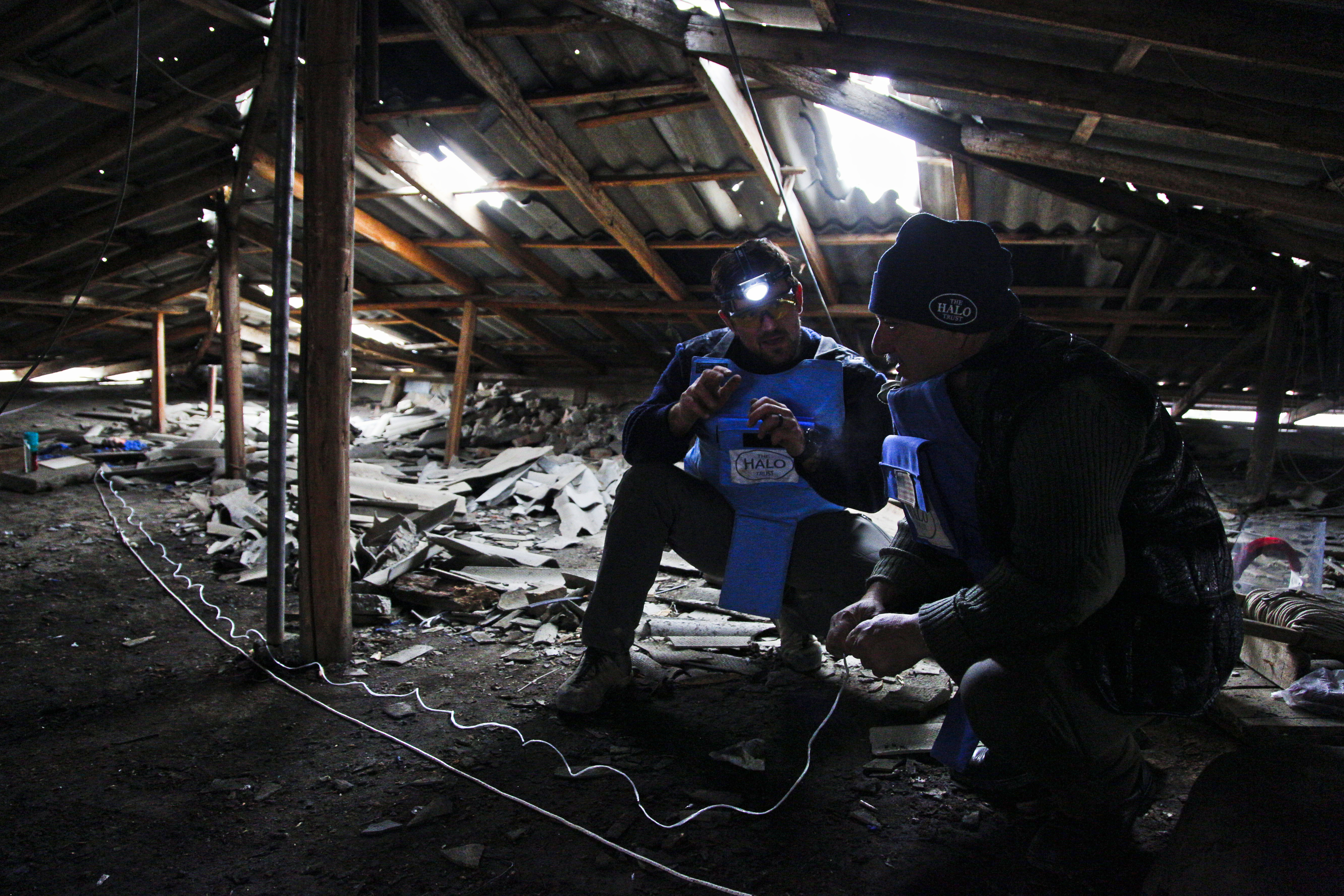 Araik Bakhshian, right, and Wes Tomson of the HALO Trust prepare to remove an unexploded cluster submunition from the loft of an apartment block in Stepanakert