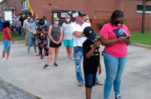 Voters wearing masks wait in line to vote early outside the Chatham County Board of Elections office in Savannah, Ga., on Wednesday, Oct. 14, 2020. (AP Photo/Russ Bynum)