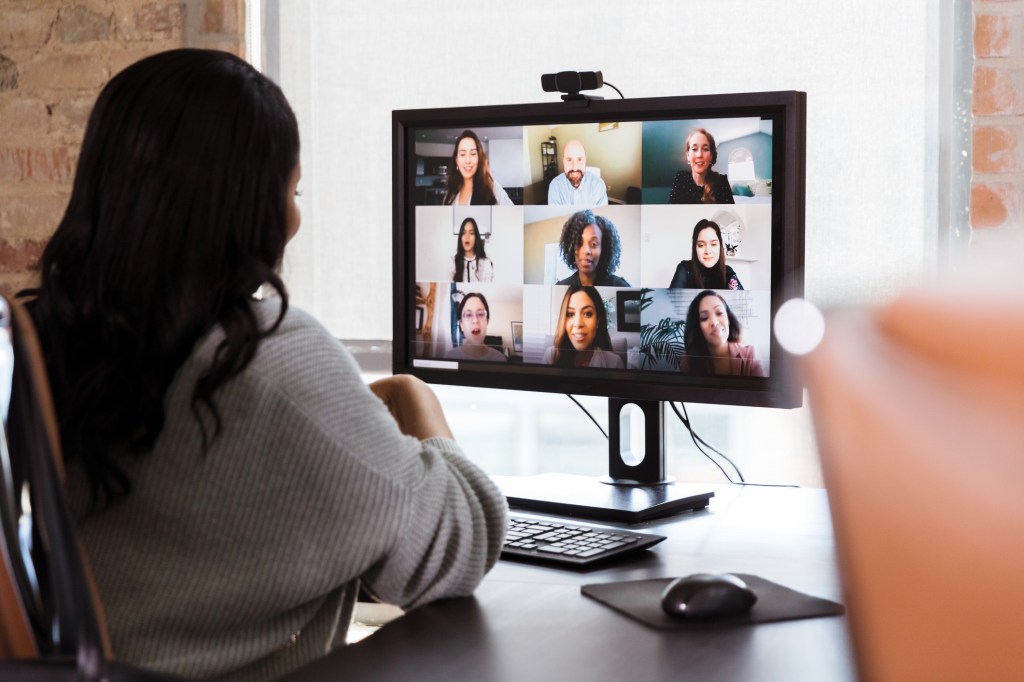 Businesswoman meets with colleagues during virtual staff meeting - stock photo