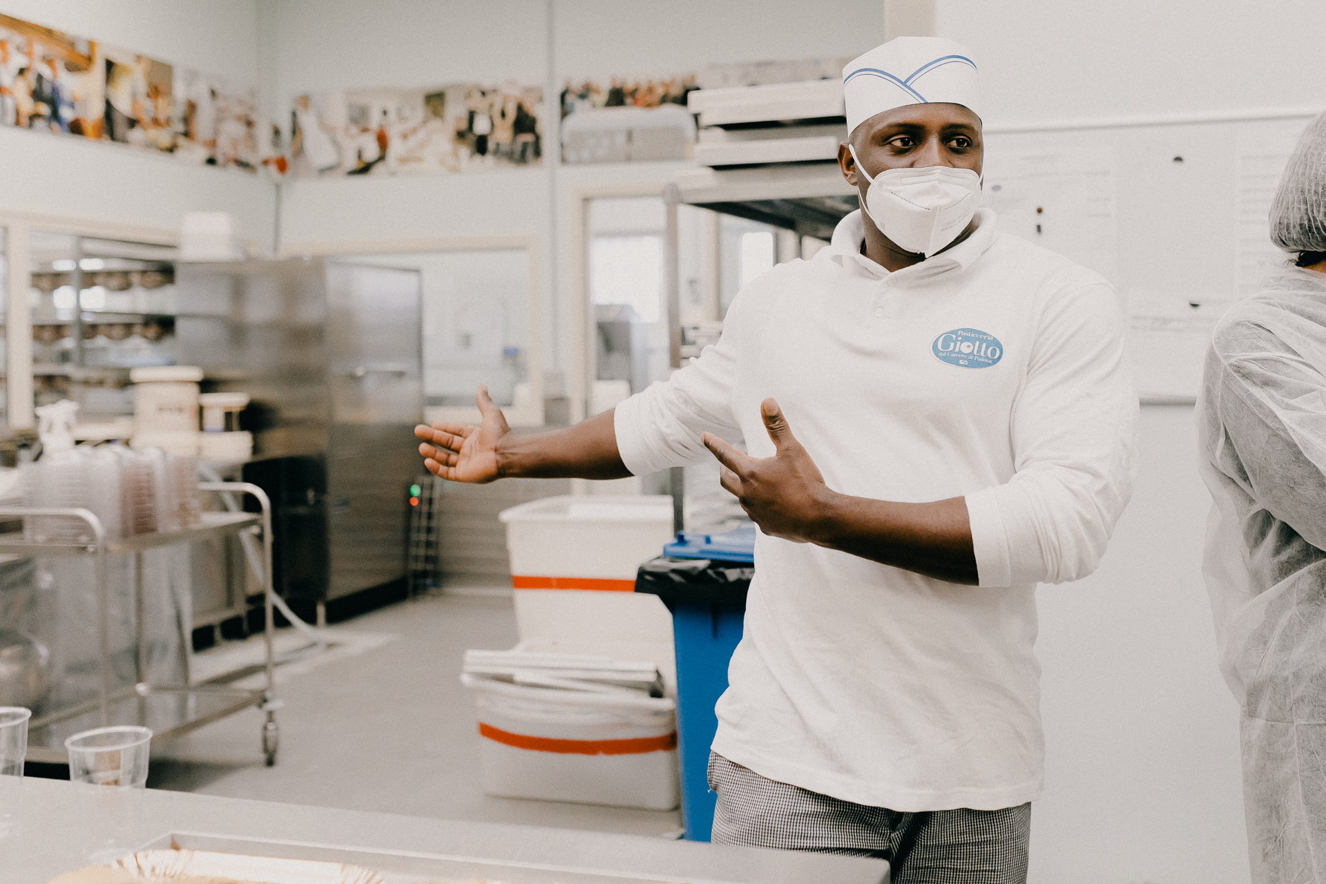 Giotto Bakery – A man gesturing towards some of the equipment in the bakery.