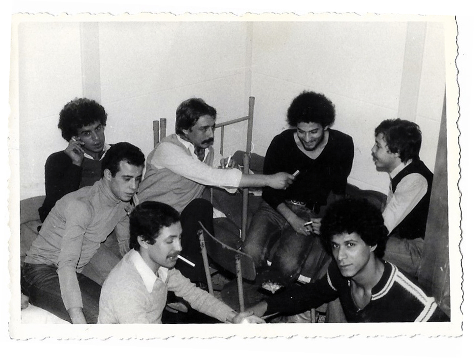 Mohammed Cheurfi – Group of young men sitting on chairs, smoking and talking. Black and white picture.