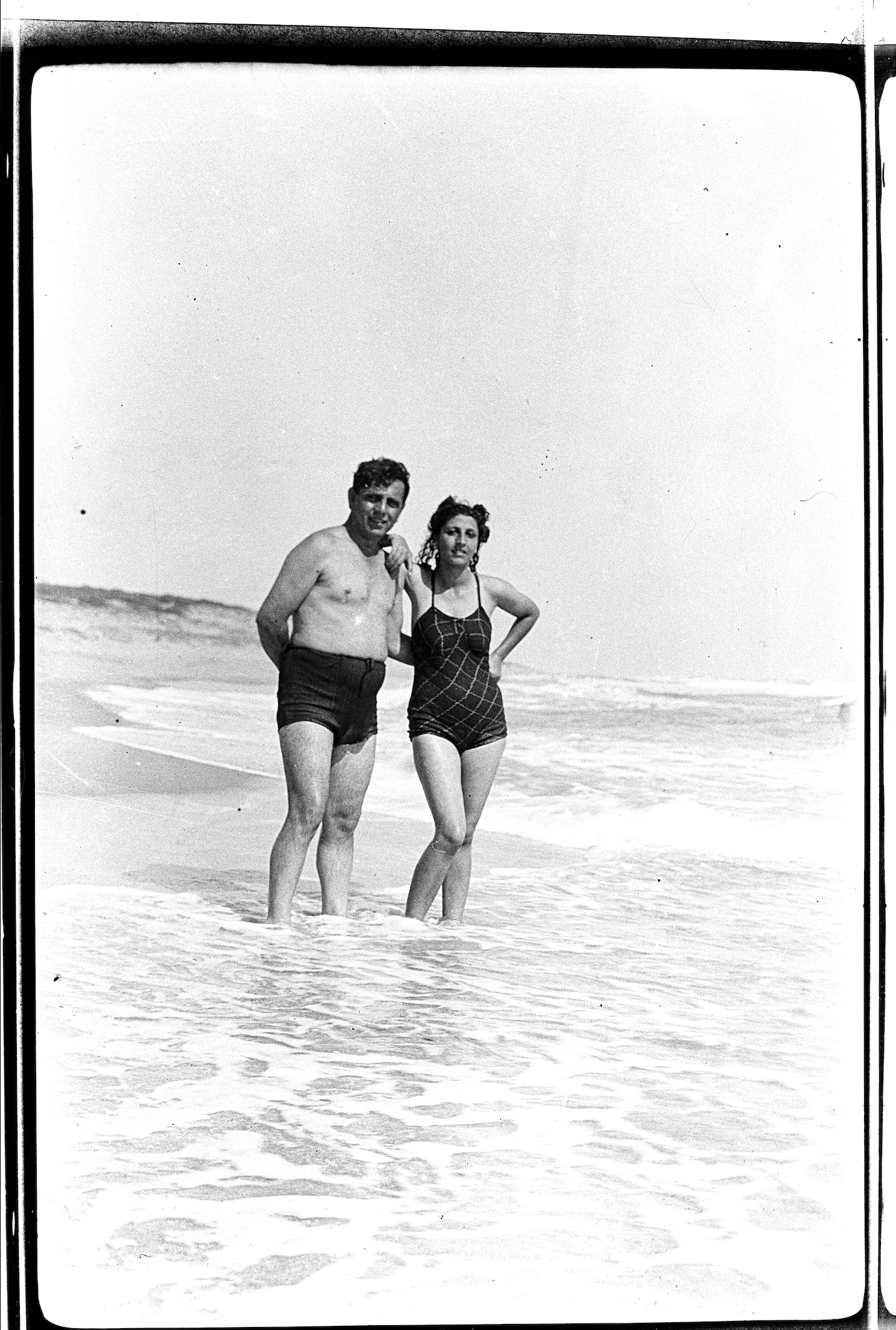 Ein altes Schwarzweißfoto mit einem Paar am Strand