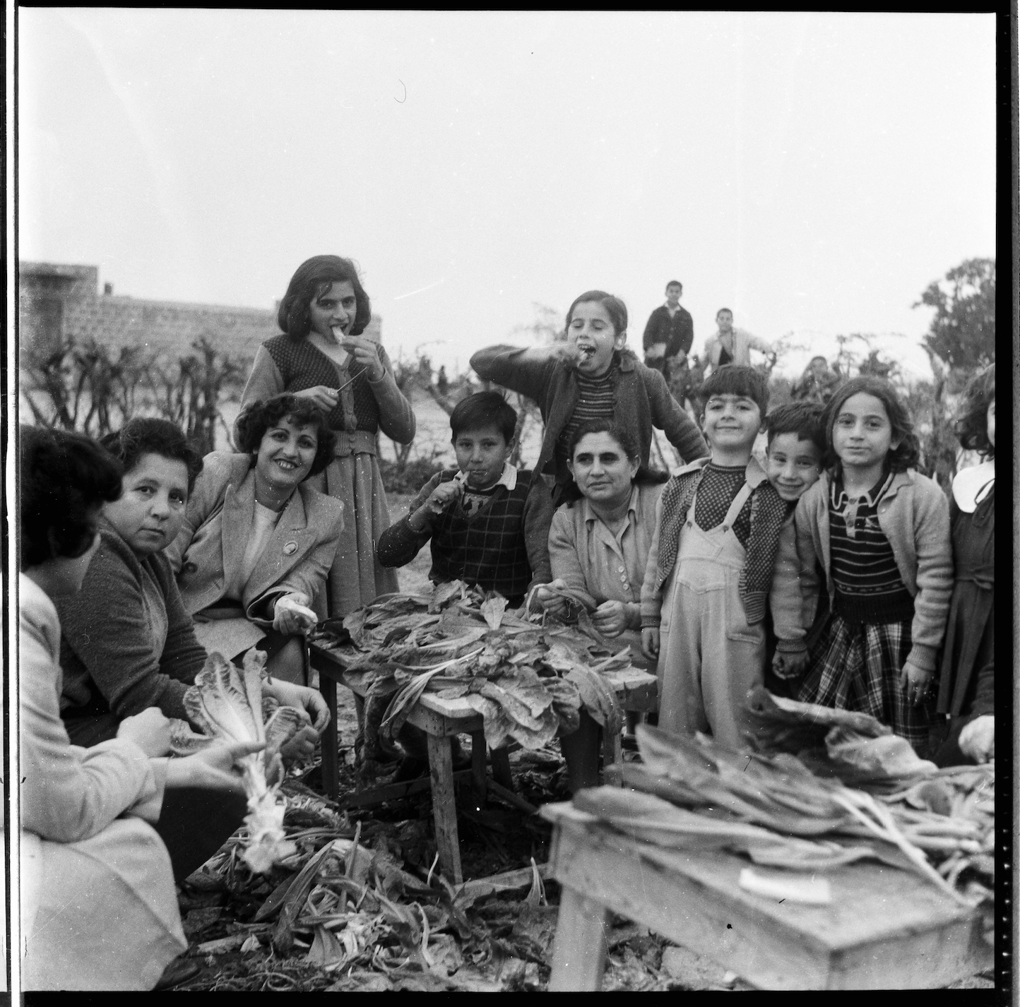 Gruppenfoto mit Kindern und Frauen beim Putzen von Gemüse