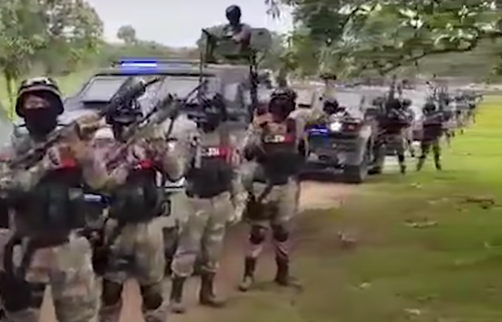 Una captura de pantalla de un video que surgió el año pasado que muestra a decenas de presuntos miembros del CJNG vestidos con equipo táctico, llevando armas de grado militar, y parados junto a un convoy de versiones artesanales de tanques de guerra y cam