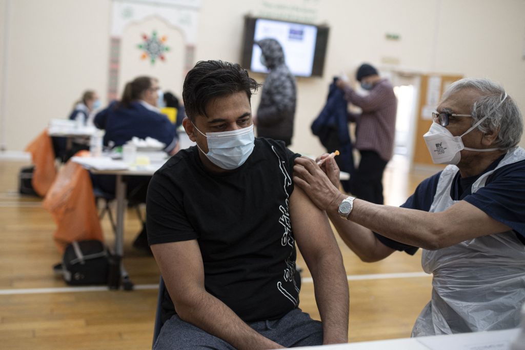 A health worker administers a dose of the AstraZeneca/Oxford Covid-19 vaccine to a patient at a vaccination centre set up at the Karimia Institute Islamic centre and Mosque in Nottingham, central England on April 6, 2021. Photo: OLI SCARFF / AFP