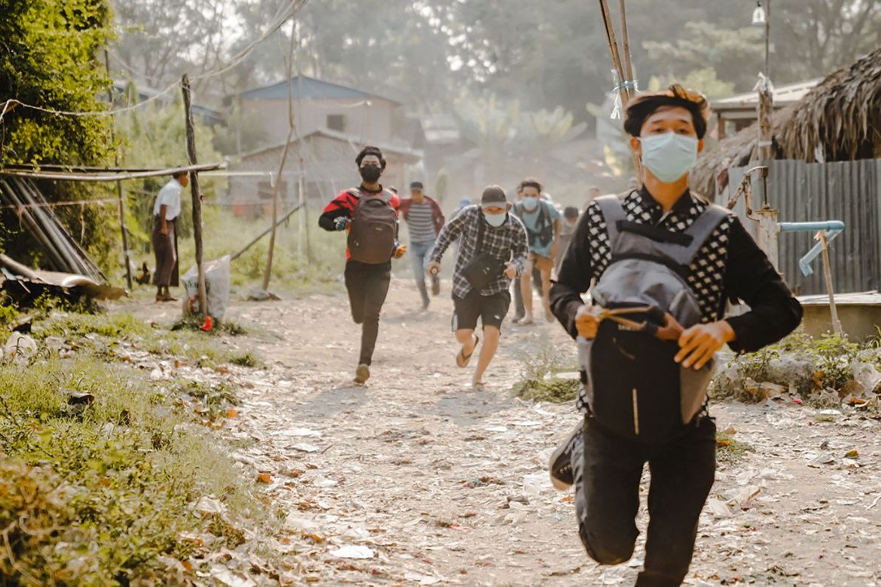 Protesters fleeing armed forces in Mandalay. PHOTO: AFP