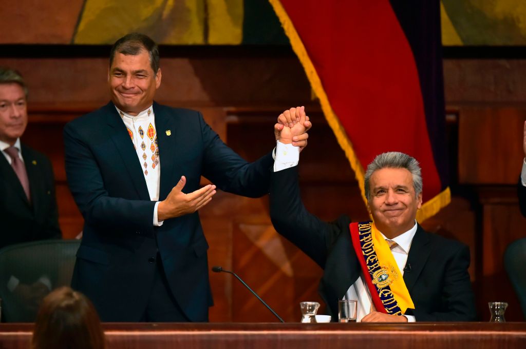 Ecuadorean former President Rafael Correa (L) raises Ecuadorean then new President Lenin Moreno's hand at the National Assembly in Quito on May 24, 2017, during Moreno's inauguration ceremony.