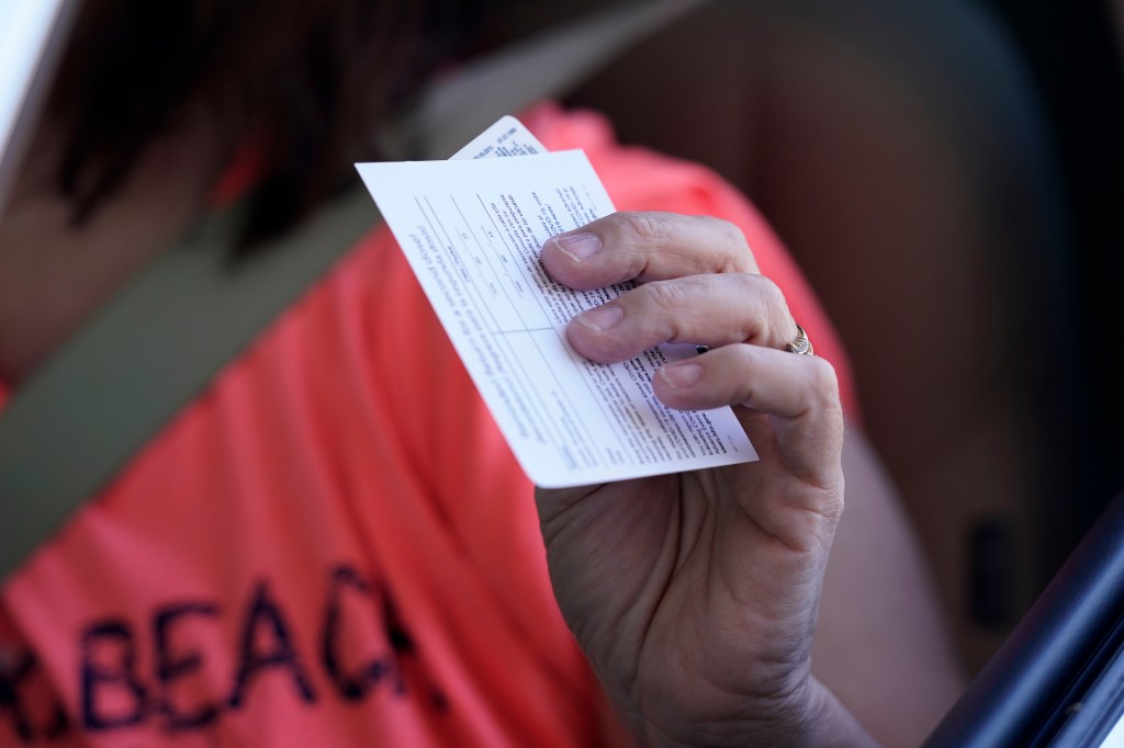 Sandy Boeckl holds her inoculation card Monday, March 29, 2021, at "Vaccine Fest," a 24-hour COVID-19 mass vaccination event in Metairie, La. (AP Photo/Gerald Herbert)