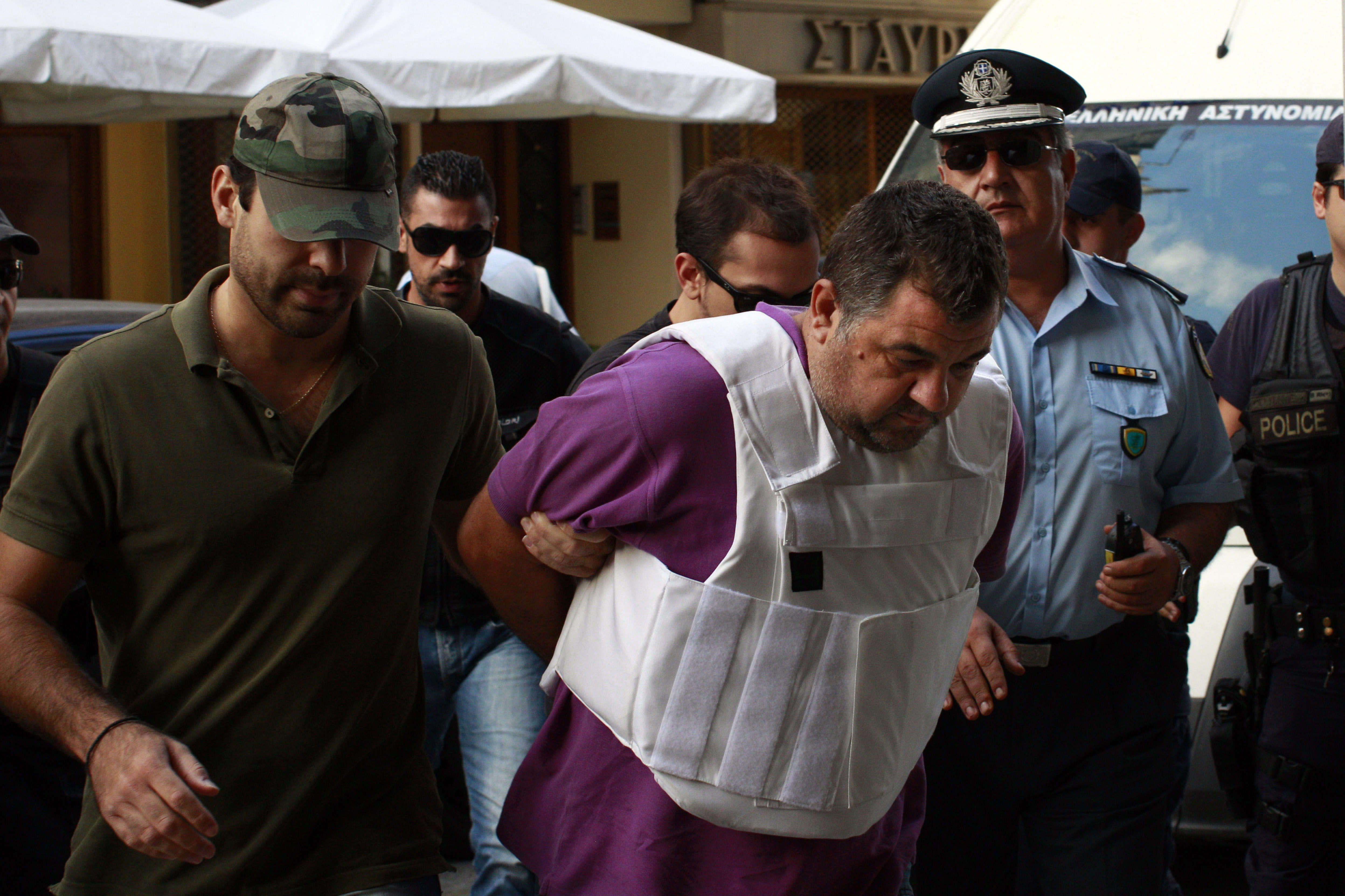 Police escort Giorgos Roupakias to court in 2013. Photo: Milos Bicanski/Getty Images