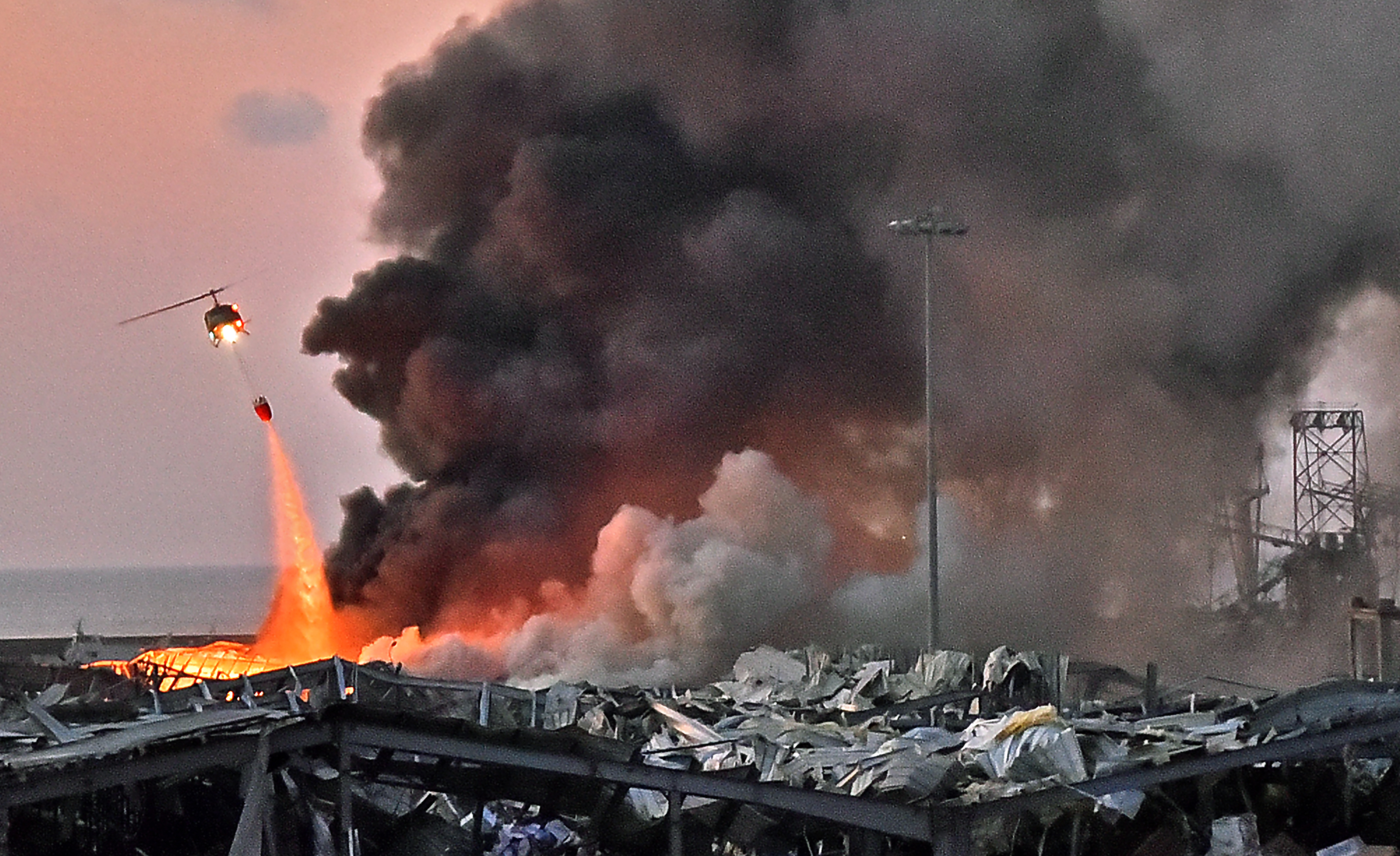 A helicopter puts out a fire at the scene of last year's explosion. Photo: STR/AFP via Getty Images