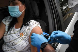 A nurse gives a shot of the Johnson & Johnson COVID-19 vaccine to Naieth Cortez at a drive-thru vaccination site targeted to Asian Americans and Pacific Islanders at Michael McCoy Elementary School. Three states have paused the administration of Johnson &