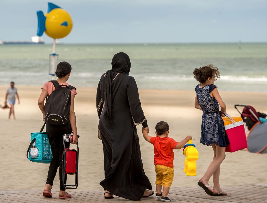 A woman wearing the Islamic hijab walks with children on the beach in Malo-Les-bains, northern France.