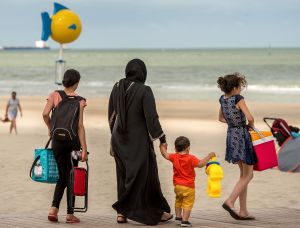 A woman wearing the Islamic hijab walks with children on the beach in Malo-Les-bains, northern France.