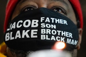 Jacob Blake Sr., father of Jacob Blake, holds a candle at a rally Monday, Jan. 4, 2021, in Kenosha, Wis. (AP Photo/Morry Gash)