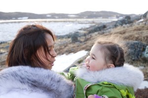 An Inuit mother interacts with her daughter on the remote tundra of Baffin Island in late spring.