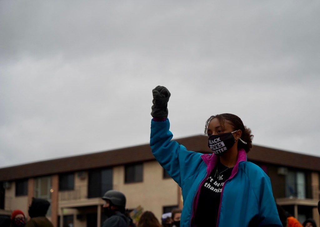 A protester raises her fist in front of the police precinct in Brooklyn Center, Minnesota on April 14, 2021, during a protest against the killing of Daunte Wright.