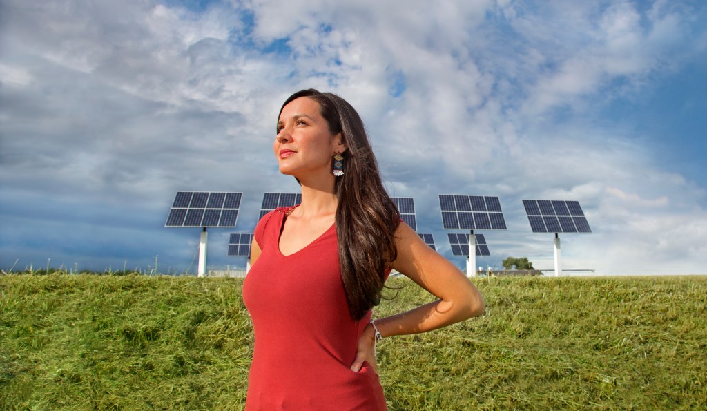 Melina Laboucan-Massimo in front of solar panels in Little Buffalo