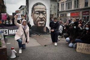 Demonstrators kneel in front of a mural depicting George Floyd during a "Kill the Bill" protest in Manchester City Centre on March 27, 2021 in Manchester, United Kingdom. Photo: Christopher Furlong/Getty Image