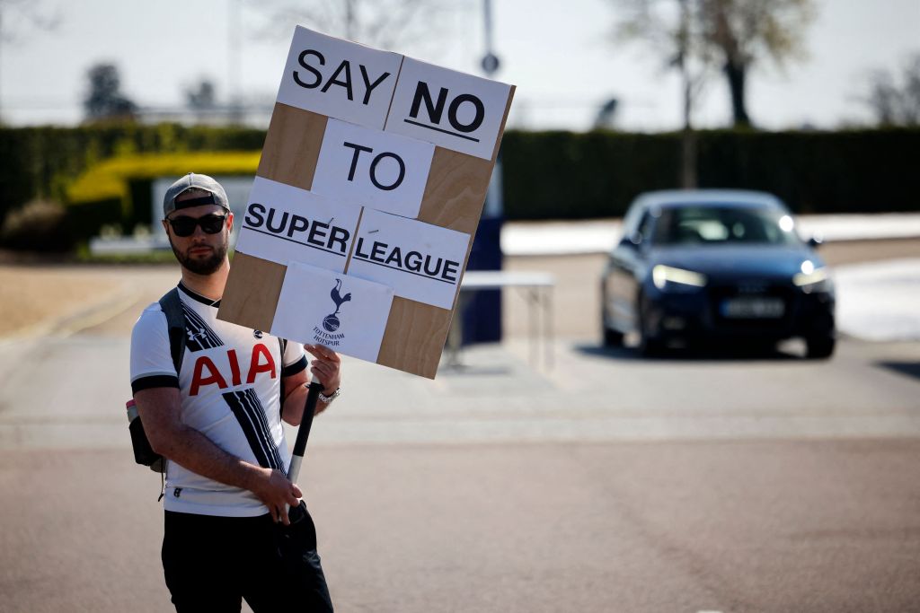 A Tottenham Hotspur's fan holds an anti-European Super League placard has he demonstrates outside the English Premier League football club's training ground in north London. Arsenal and Tottenham Hotspur were both bailed out by the UK taxpayer to the tune