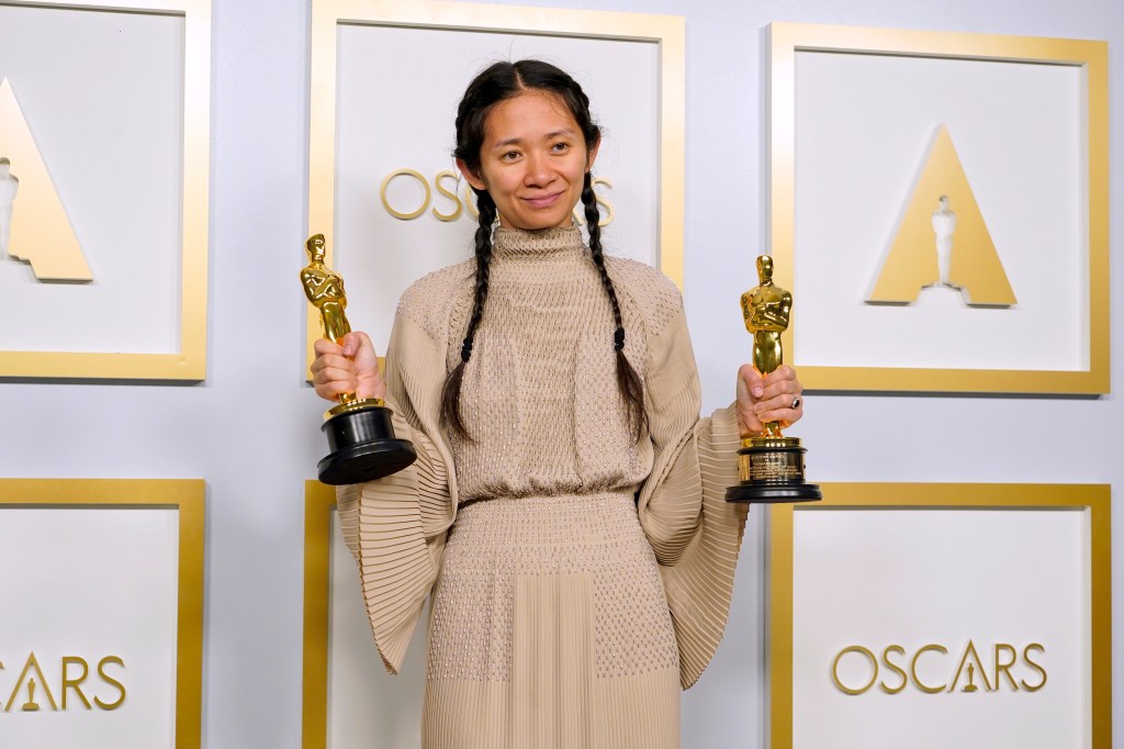 director and producer chloe zhao poses with two oscars at the 2021 academy awards, where she won best picture and best director for nomadland