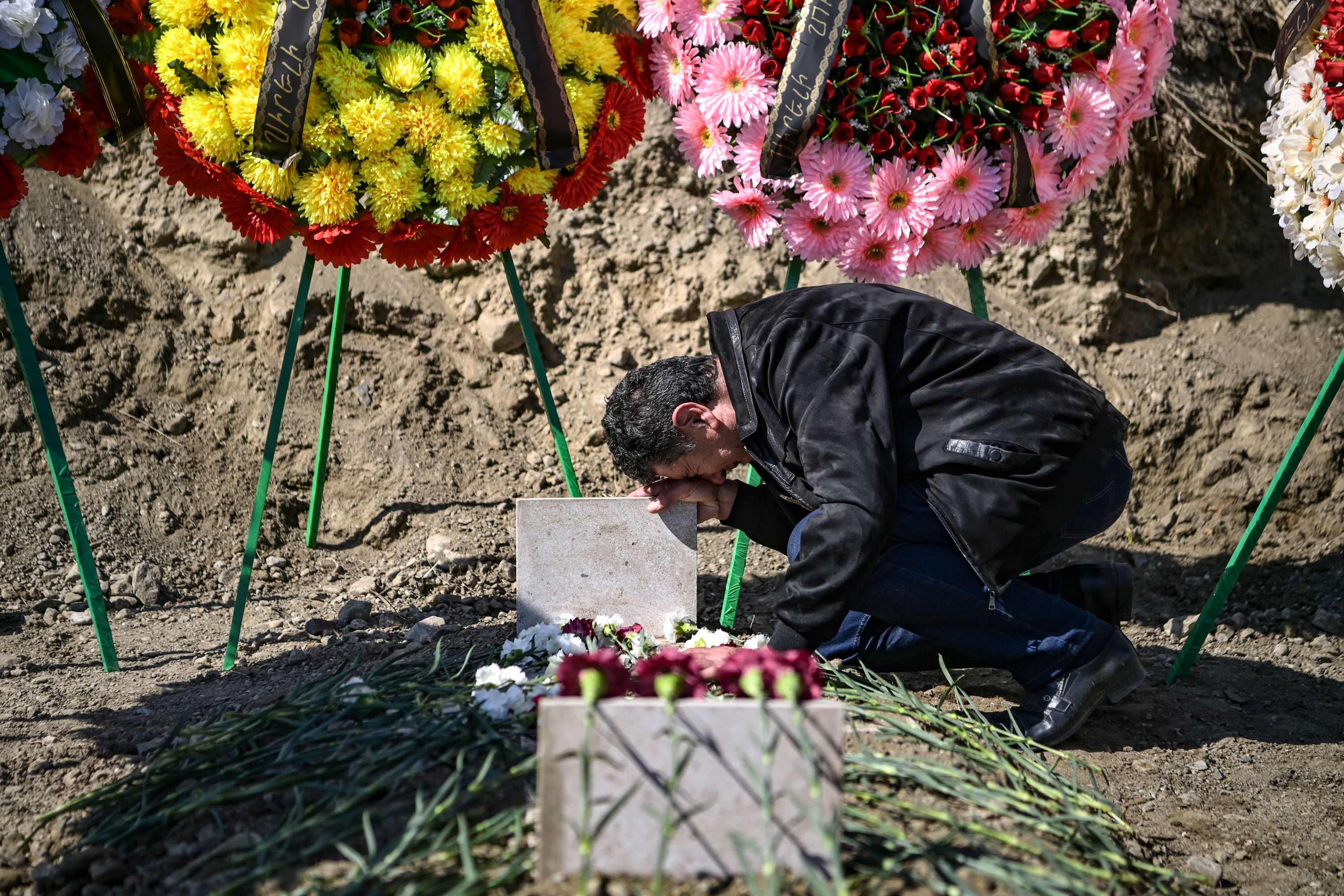 A man mourns at the grave of a fellow fighter in Stepanakert, the regional capital of Nagorno-Karabakh, in October last year. Photo: ARIS MESSINIS/AFP via Getty Images