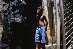 A police officer from the anti-drug squad searches a home in the the Pixunga favela in Rio de Janeiro, Brazil.