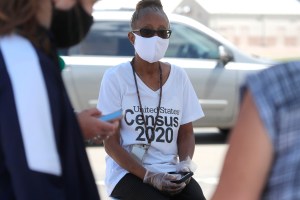 Amid concerns of the spread of COVID-19, census worker Jennifer Pope wears a mask and sits by ready to help at a U.S. Census walk-up counting site set up for Hunt County in Greenville, Texas, Friday, July 31, 2020.