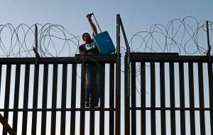 Migrants attempt to cross into the United States from Mexico over a fence at the border on April 21, 2021 in San Luis, Arizona.