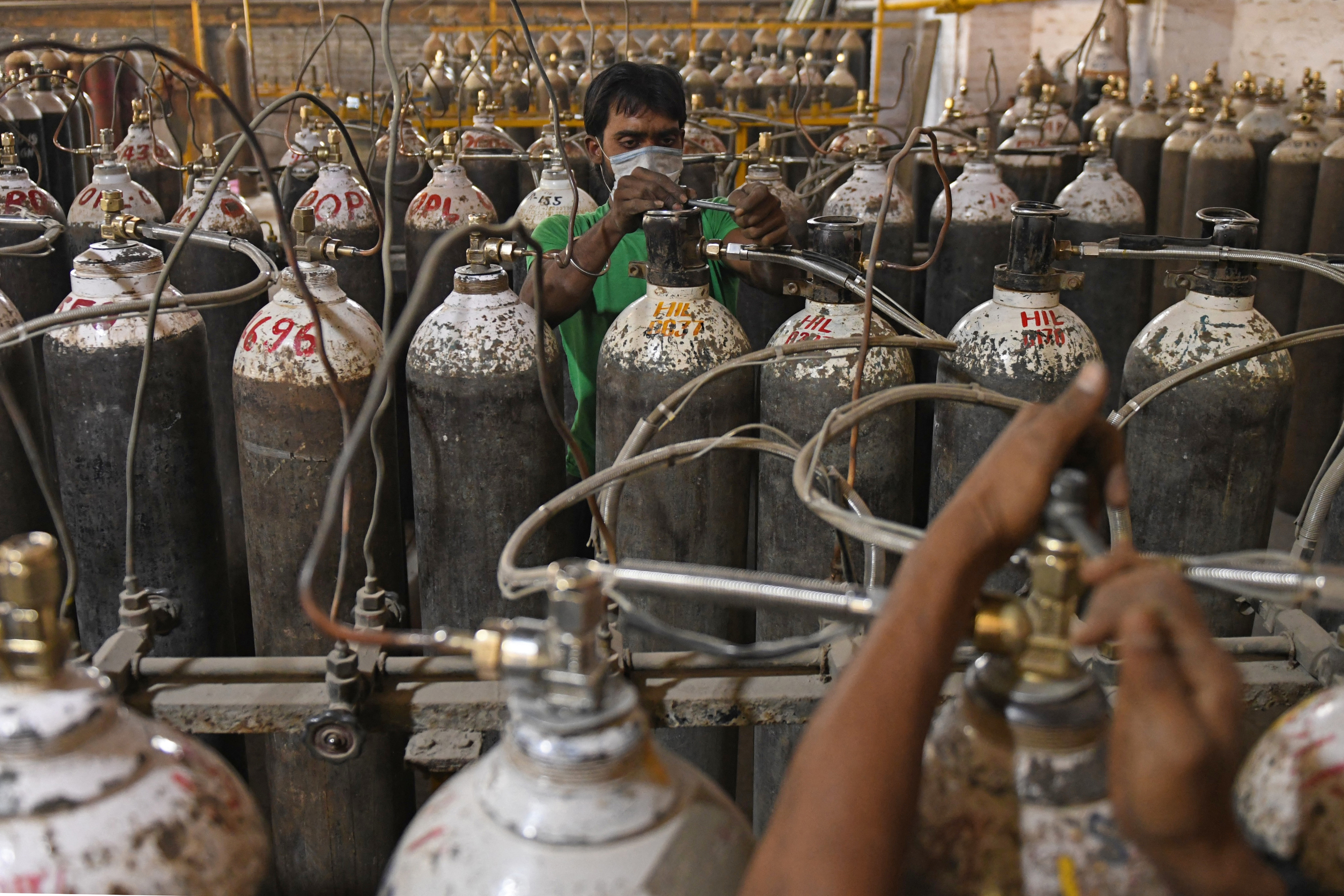 Workers sort oxygen cylinders before dispatch at a facility on the outskirts of Amritsar. PHOTO: NARINDER NANU / AFP