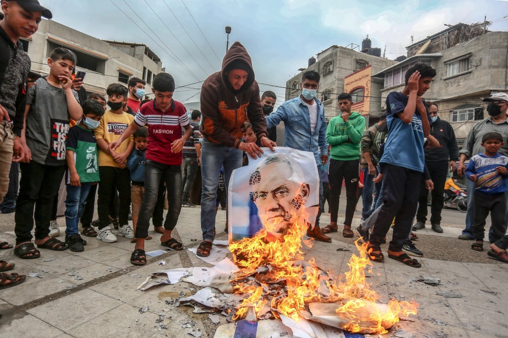 Palestinian protesters burn pictures of Israeli Defence Minister, Benny Gantz, and an Israeli flag in Khan Yunis, south of the Gaza Strip.