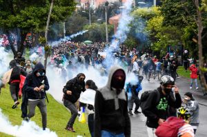 Demonstrators clash with riot police during a protest against a tax reform bill outside Colombian President Ivan Duque's house in Bogota on May 1, 2021.