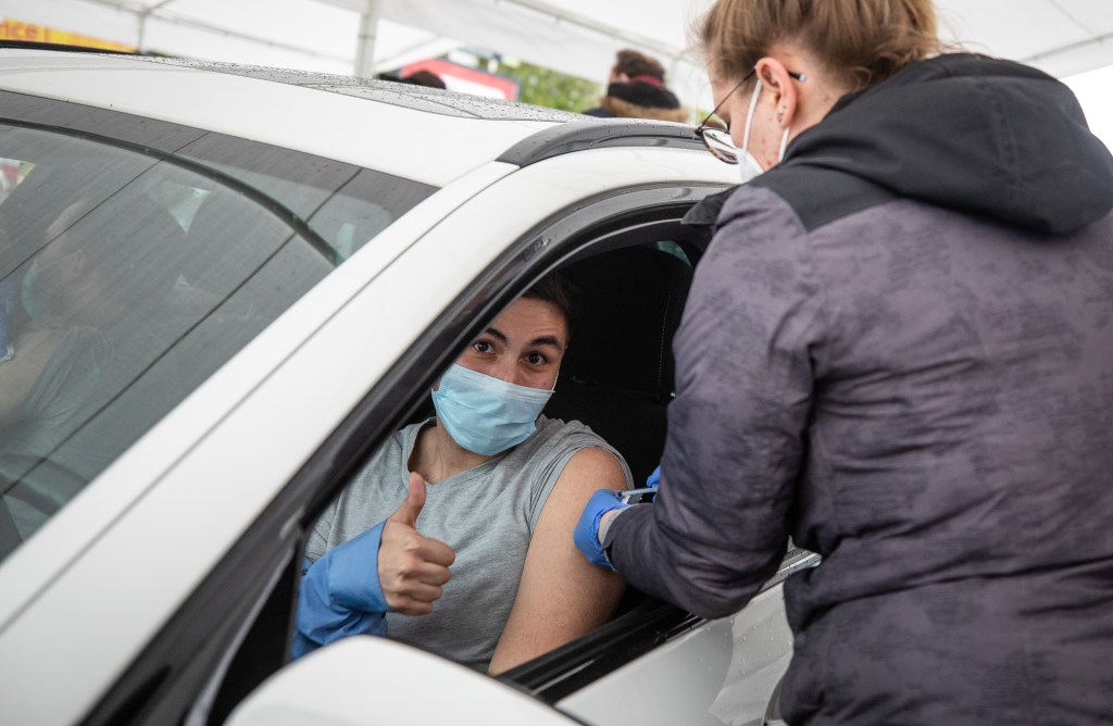 Young man gets COVID-19 vaccine whilk in his car