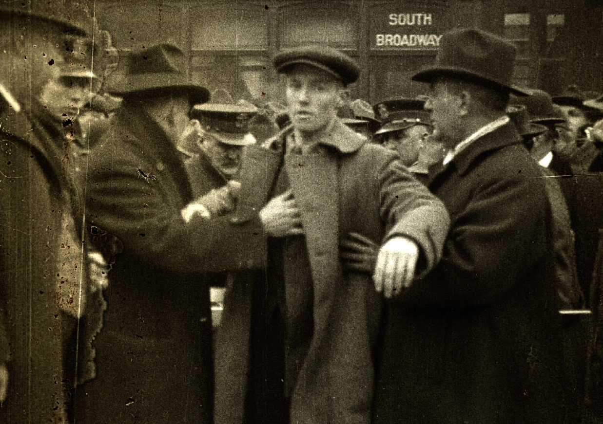 A man tries to break a police line outside the Lexington, Kentucky, courthouse in 1920, where a Black war veteran is on trial for the murder of a young white girl. 