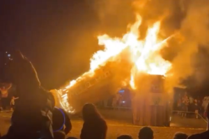 ​An image of a giant syringe being burned in effigy.