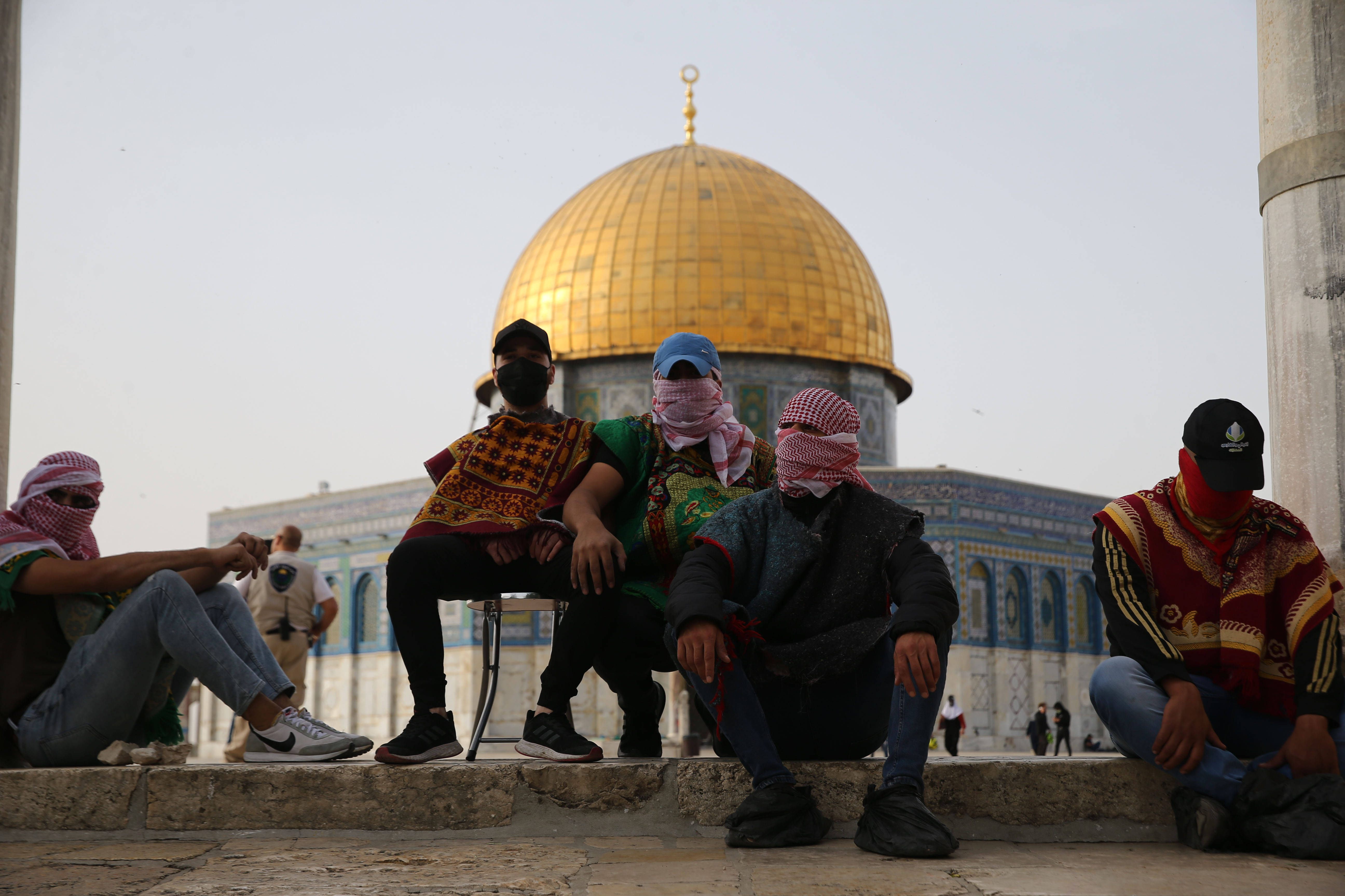 Pengunjuk rasa Palestina berjaga-jaga di depan pintu masuk Masjid Al-Aqsa. Foto: Mostafa Alkharouf/Anadolu Agency via Getty Images