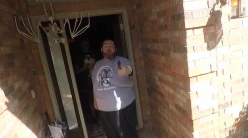 A screenshot of a video in which Steven Williams points his gun at the camera.