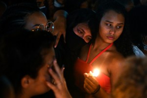 A woman holds up a candle during a protest on May 7 2021, the day after a deadly police operation in the Jacarezinho favela. More than two dozen people died in the bloodiest police operation in the history of Rio de Janeiro.