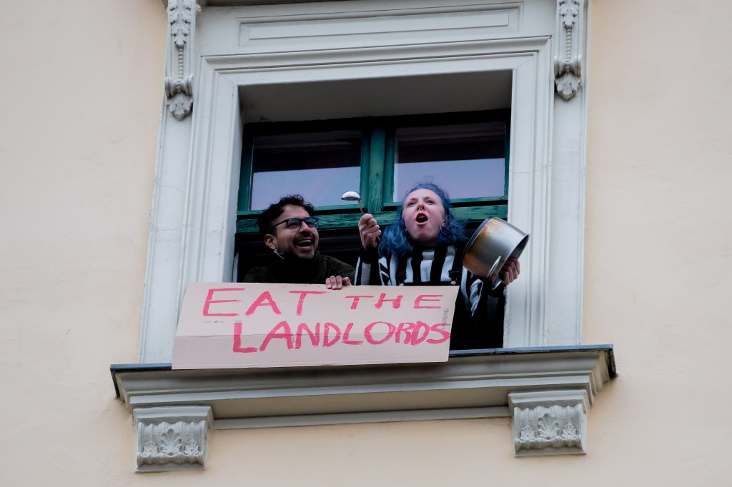 A man and a woman protest after the german court overrules Berlin's rent cap. Photo: Christoph Soeder/picture alliance via Getty Images.