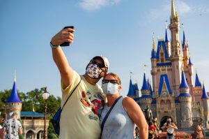 Masked couple takes selfie at Disney World during COVID-19 pandemic.