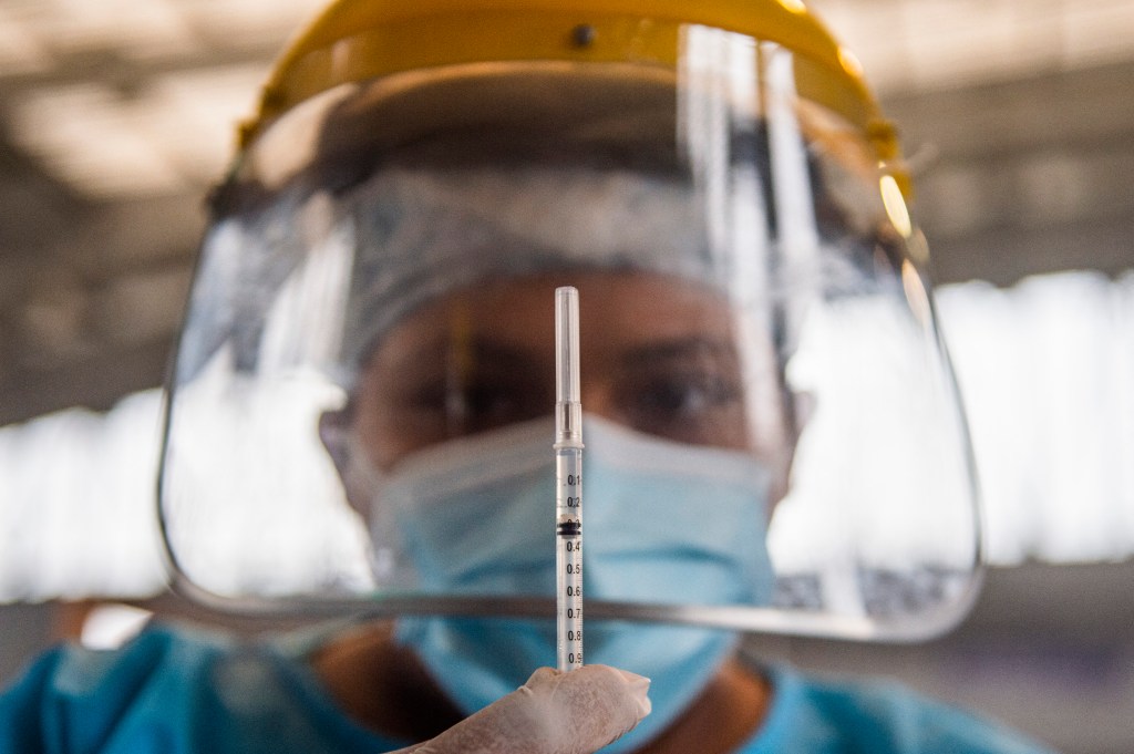 A health worker prepares a dose of the Pfizer-BioNTech vaccine against COVID-19 in Lima on April 23, 2021.