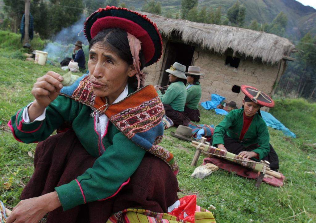 Una mujer andina de Cha'ri, a unos 150 kms al sur de Cusco, Perú, realiza una ofrenda de hoja de coca antes de comenzar su trabajo textil el 28 de enero de 2008. Foto: JAIME RAZURI/AFP vía Getty Images.​